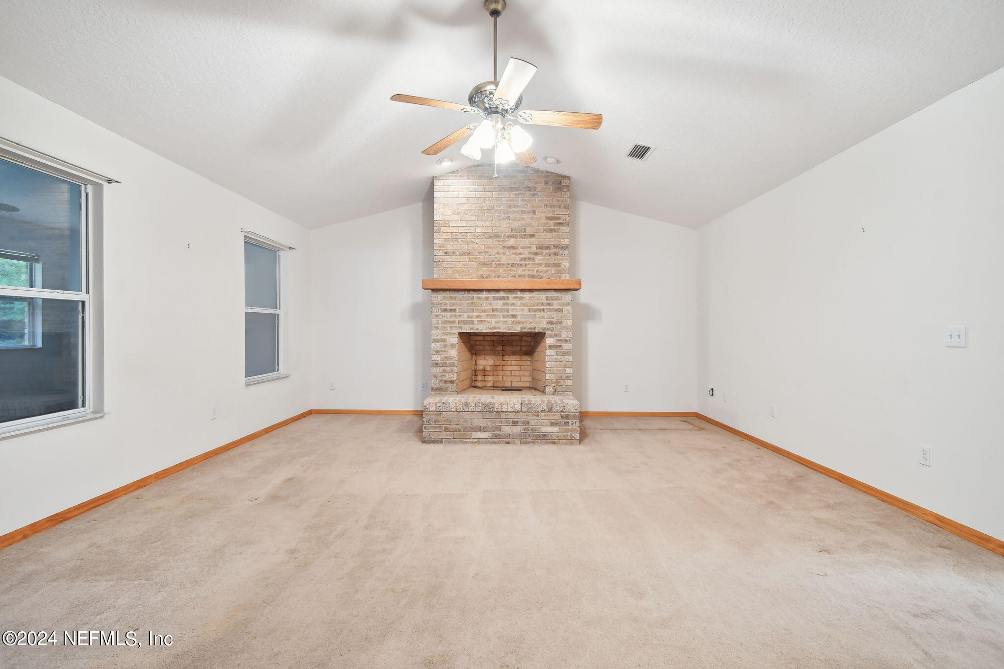 36068 J W Elliott Road Callahan, FL 32011 - Photo 8 of 54 a view of an empty room with a fireplace and a window
