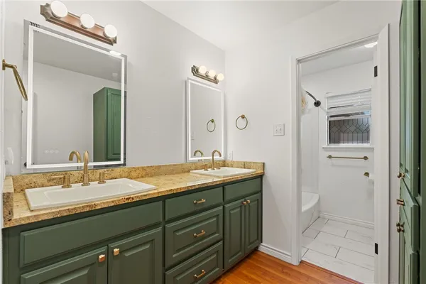 a bathroom with a granite countertop sink and a mirror
