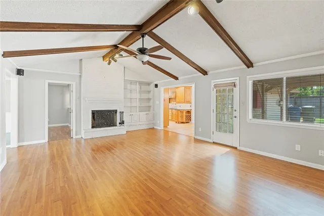 a view of empty room with wooden floor and fireplace