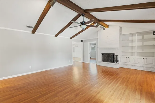 a view of a livingroom with wooden floor and staircase