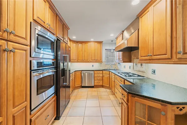a kitchen with granite countertop a stove a sink and a refrigerator