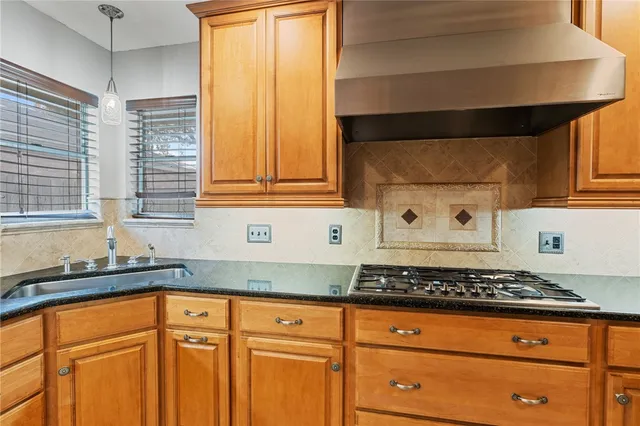 a kitchen with granite countertop cabinets stainless steel appliances a sink and a window