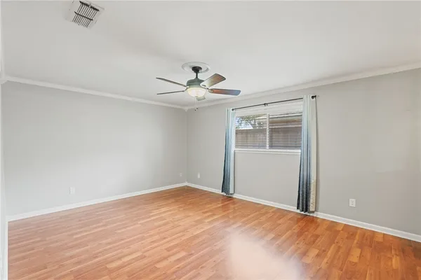 a big room with wooden floor closet and chandelier fan