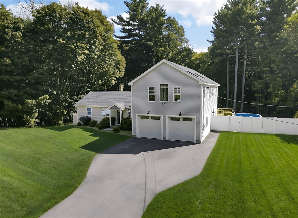 57 Parham Road Tyngsborough, MA 01879 - Photo 2 of 42 a front view of a house with a yard and trees