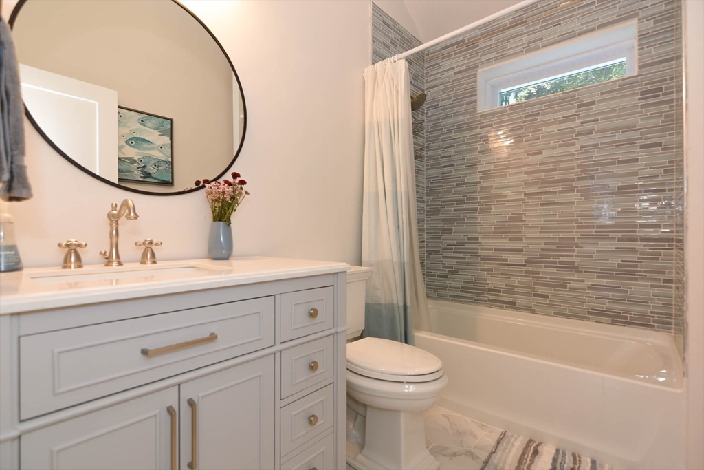 57 Parham Road Tyngsborough, MA 01879 - Photo 23 of 42 a bathroom with a toilet a sink a mirror and bathtub