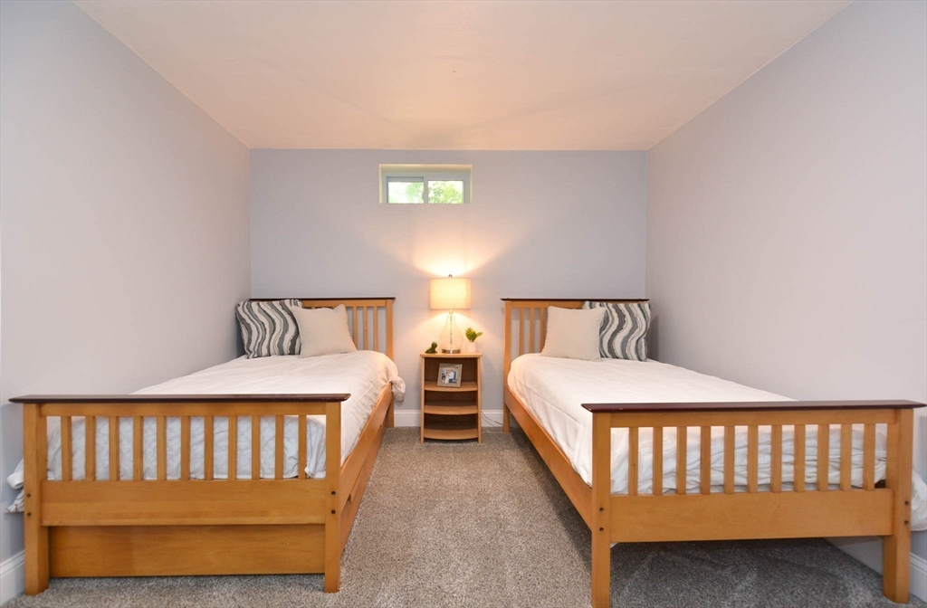 57 Parham Road Tyngsborough, MA 01879 - Photo 30 of 42 a bedroom with a bed and a night stand with exposed radiator