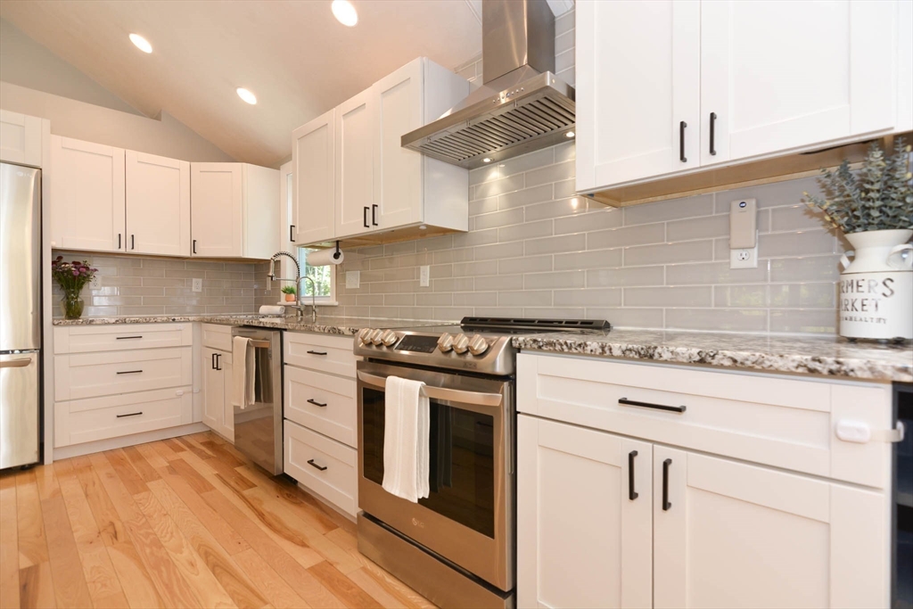 57 Parham Road Tyngsborough, MA 01879 - Photo 4 of 42 a kitchen with granite countertop a stove oven and white cabinets