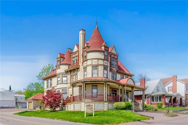 a front view of residential houses with yard and green space