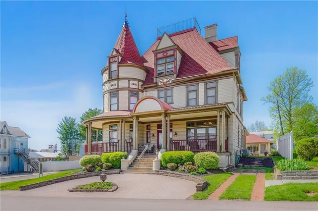 a front view of a residential apartment building with a yard and potted plants