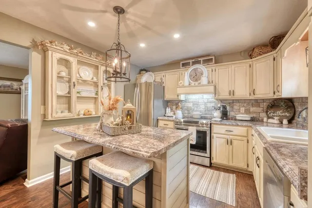 a kitchen with refrigerator cabinets and large windows