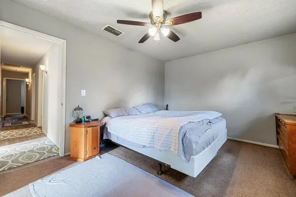 a spacious bedroom with a bed and a chandelier