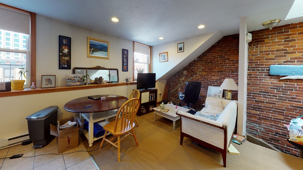 97 Hudson Street, Unit 4 Boston, MA 02111 - Photo 3 of 6 a living room with furniture and a fireplace
