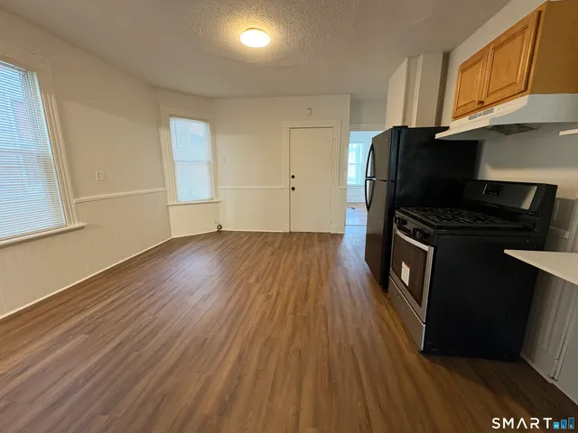 a kitchen with wooden floors and black appliances