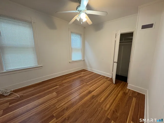 a view of a room with wooden floor and fan