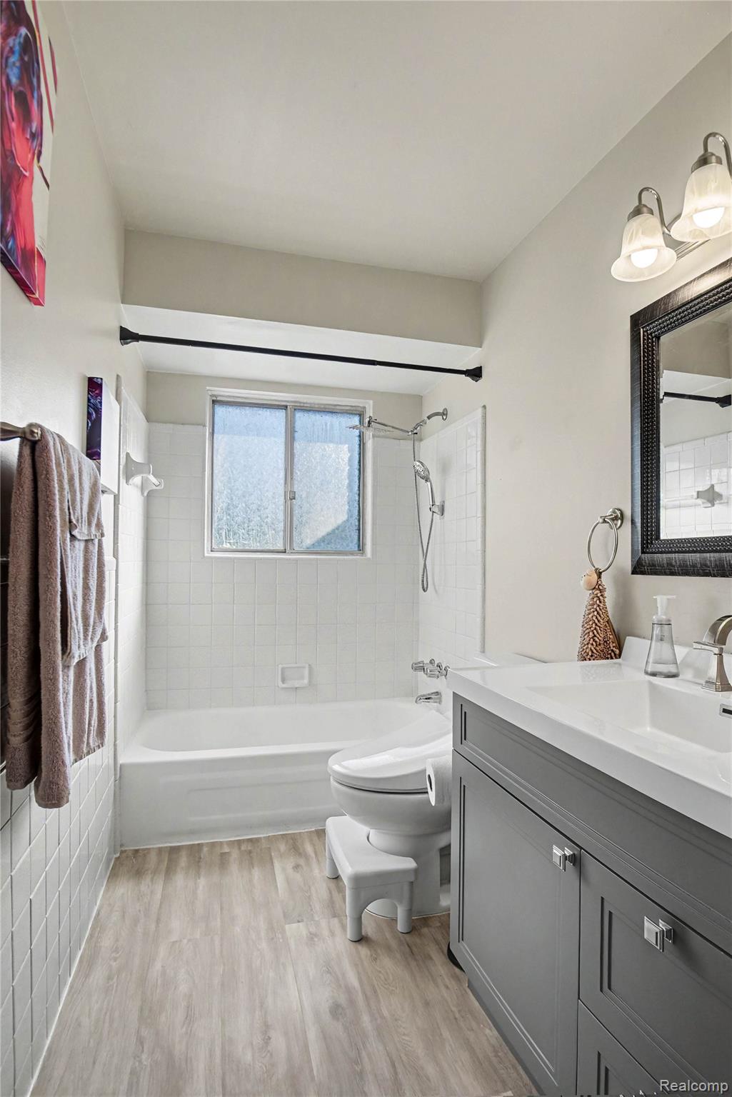 8530 Canal Road Sterling Heights, MI 48314 - Photo 17 of 31 Bathroom featuring wood-finish flooring and a white tile shower surround