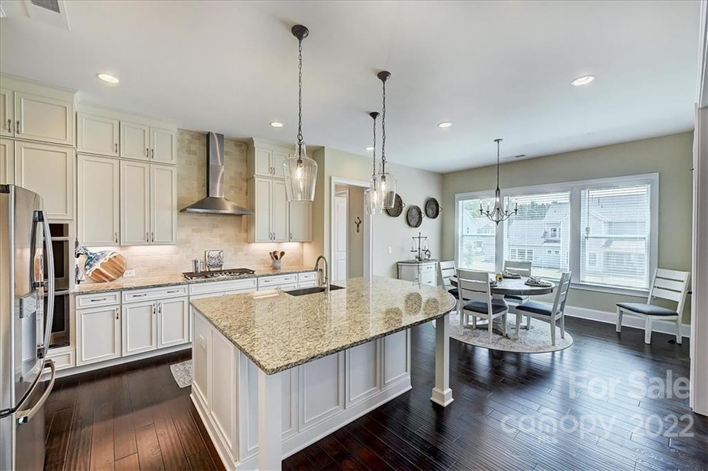 2557 Hidden Shoals Road Fort Mill, SC 29708 - Photo 9 of 30 a kitchen with granite countertop a sink appliances and wooden floor