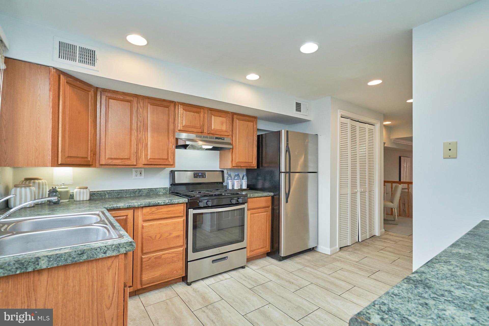 1313 K Street Southeast Washington, DC 20003 - Photo 16 of 48 a kitchen with stainless steel appliances granite countertop a refrigerator a sink a stove with wooden cabinets