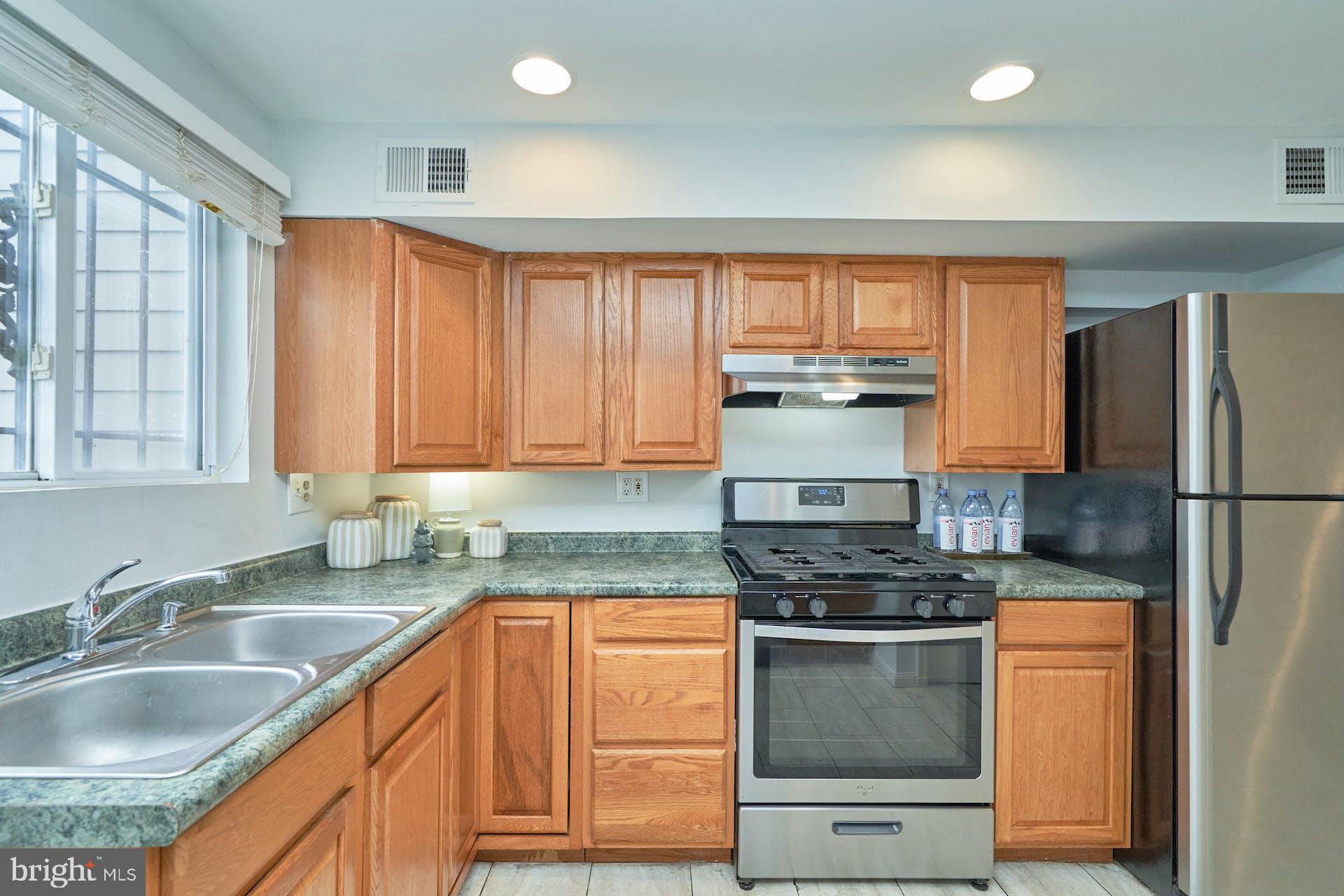 1313 K Street Southeast Washington, DC 20003 - Photo 17 of 48 a kitchen with granite countertop a sink stainless steel appliances and cabinets