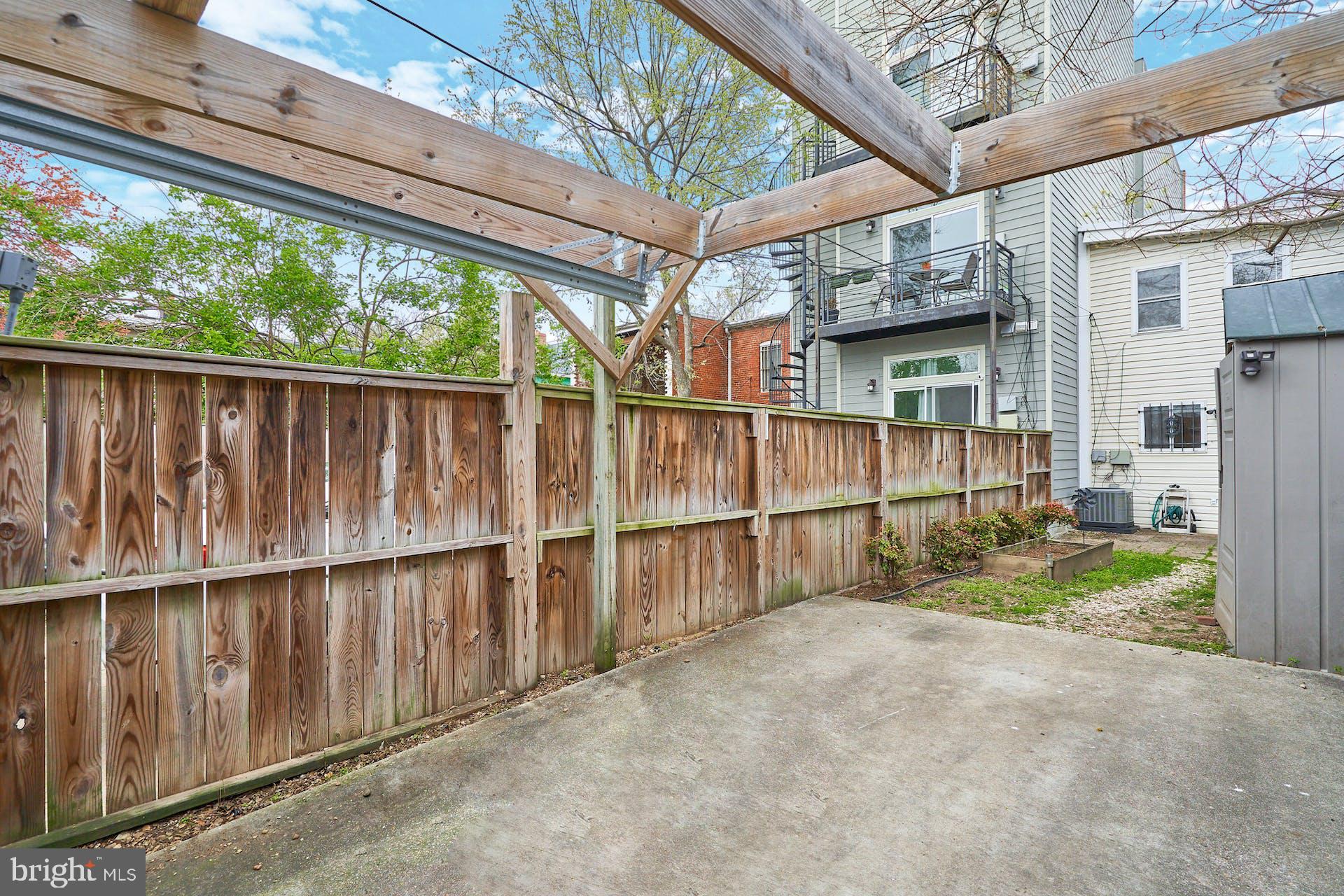 1313 K Street Southeast Washington, DC 20003 - Photo 40 of 48 a view of backyard with large tree and wooden fence
