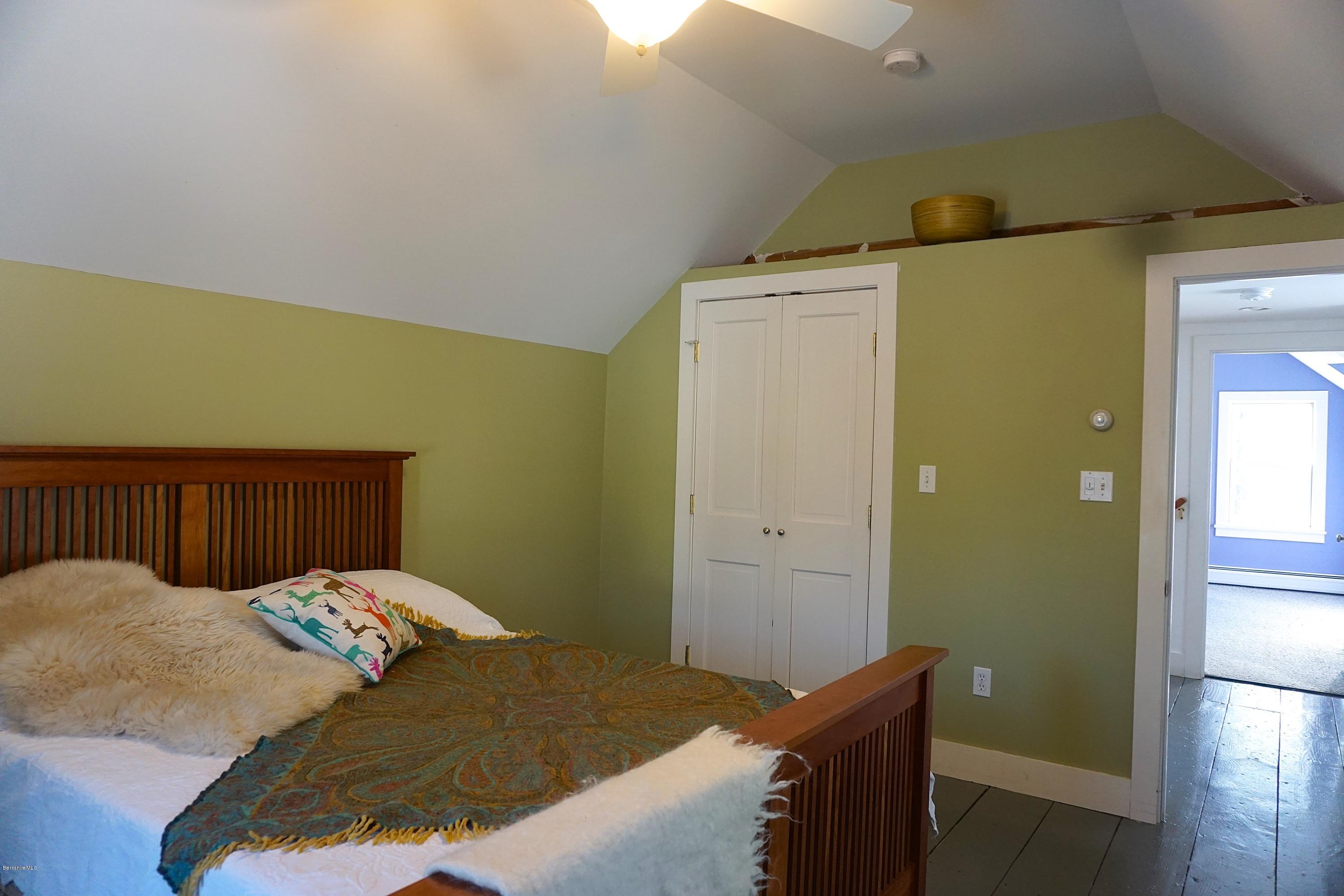 38 Sandisfield Road Monterey, MA 01245 - Photo 16 of 25 a bedroom with a bed and wooden floor