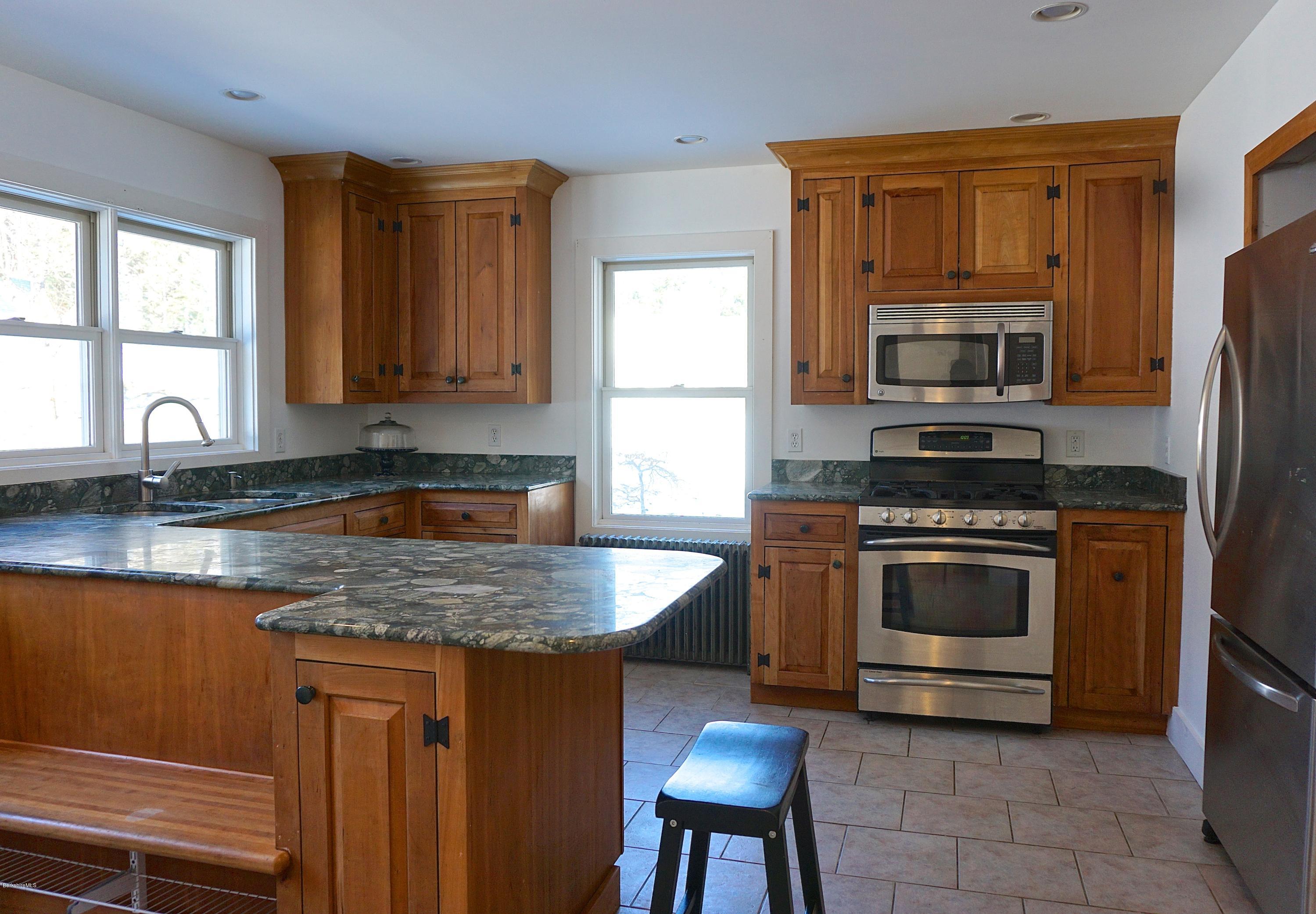 38 Sandisfield Road Monterey, MA 01245 - Photo 10 of 25 a kitchen with granite countertop a stove top oven microwave and cabinets