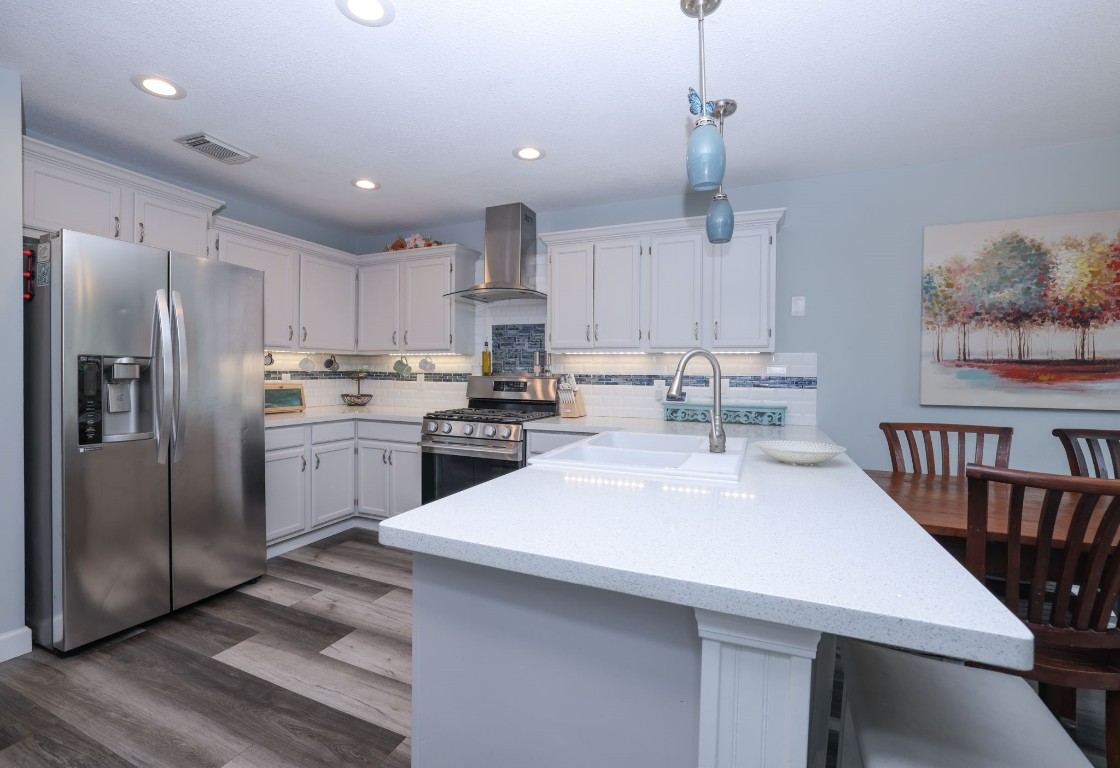 8827 Stoney Bend Drive Spring, TX 77379 - Photo 12 of 39 a kitchen with a sink stainless steel appliances and white cabinets