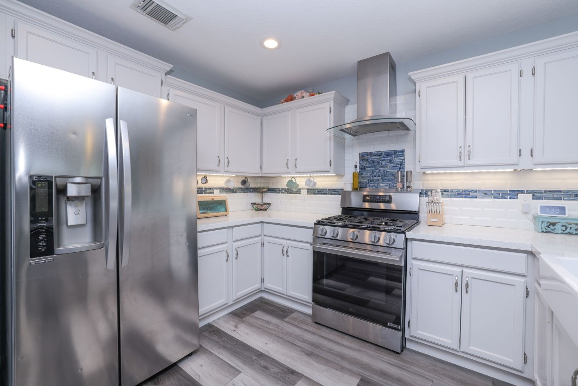 8827 Stoney Bend Drive Spring, TX 77379 - Photo 13 of 39 a kitchen with stainless steel appliances granite countertop a refrigerator a stove and white cabinets