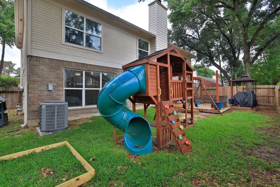 8827 Stoney Bend Drive Spring, TX 77379 - Photo 39 of 39 a view of a backyard with plants and a slide