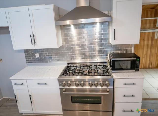 a stove top oven sitting inside of a kitchen