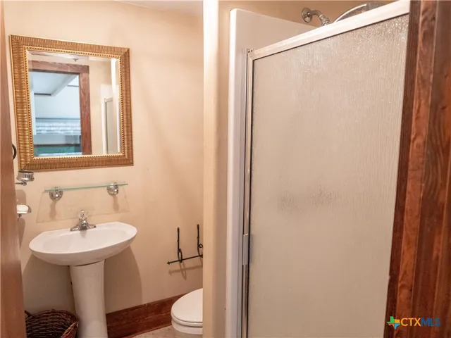 a bathroom with a sink a toilet and shower
