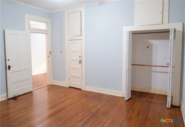 an empty room with wooden floor and closet