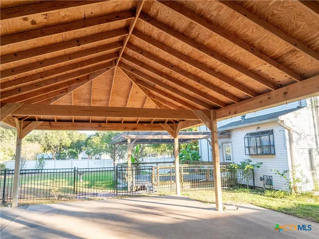 a view of a room with a large window and wooden floor
