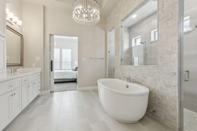 a spacious bathroom with a double vanity sink a mirror and a bathtub