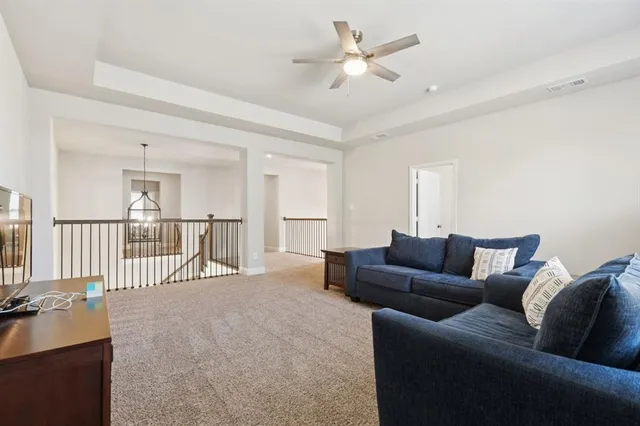 a living room with furniture and a ceiling fan