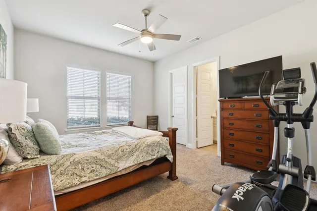 a bedroom with a bed and a flat tv screen on a dresser