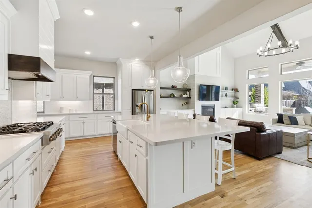 a large white kitchen with stainless steel appliances