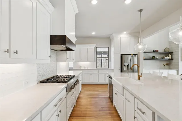 a kitchen with kitchen island a sink appliances and cabinets