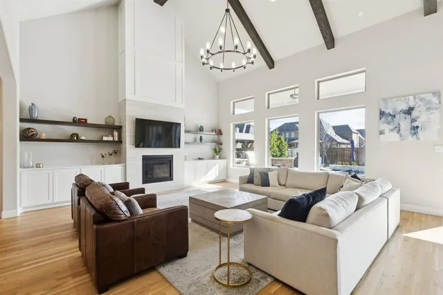 a living room with furniture a fireplace and a chandelier