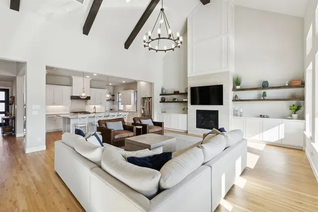 a living room with furniture a flat screen tv and kitchen view