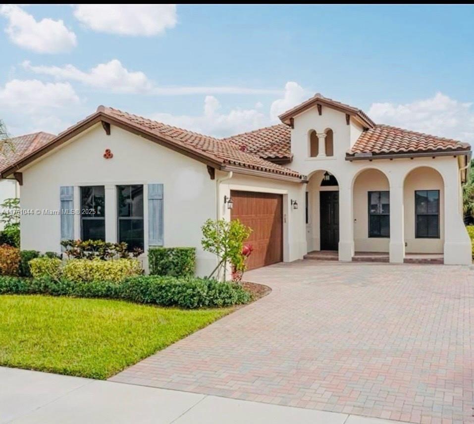 5008 Salerno Street Ave Maria, FL 34142 - Photo 1 of 46 a front view of a house with garden