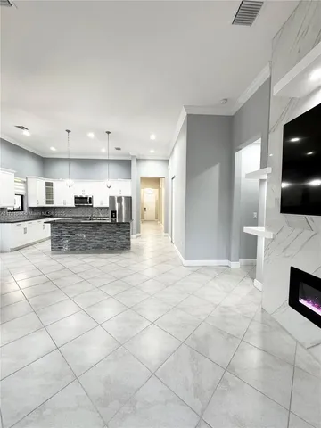 a view of a big room with a chandelier fan and windows