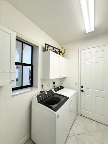 a view of a kitchen with white cabinets and window