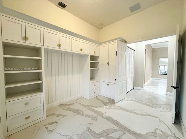a view of an empty room with cabinet and stairs