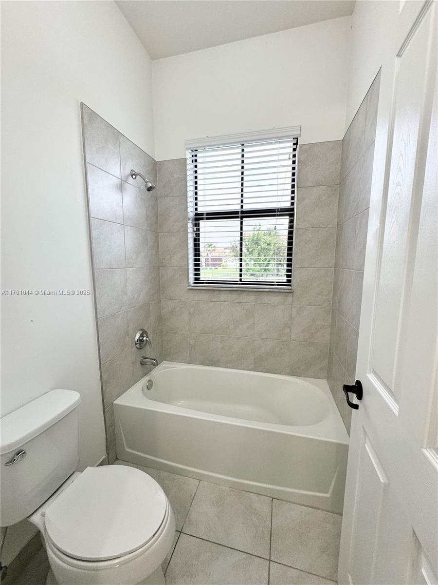 5008 Salerno Street Ave Maria, FL 34142 - Photo 17 of 46 a white bath tub sitting next to a white toilet and a window