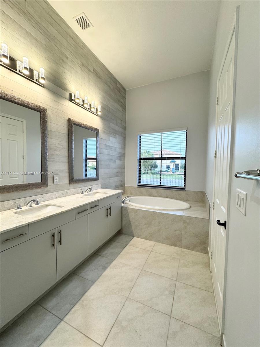 5008 Salerno Street Ave Maria, FL 34142 - Photo 24 of 46 a spacious bathroom with a tub sink shower and mirror