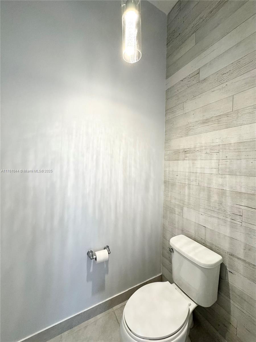 5008 Salerno Street Ave Maria, FL 34142 - Photo 26 of 46 a white toilet sitting next to a shower curtain