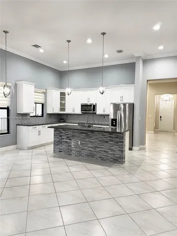 a large kitchen with kitchen island a sink stainless steel appliances and cabinets