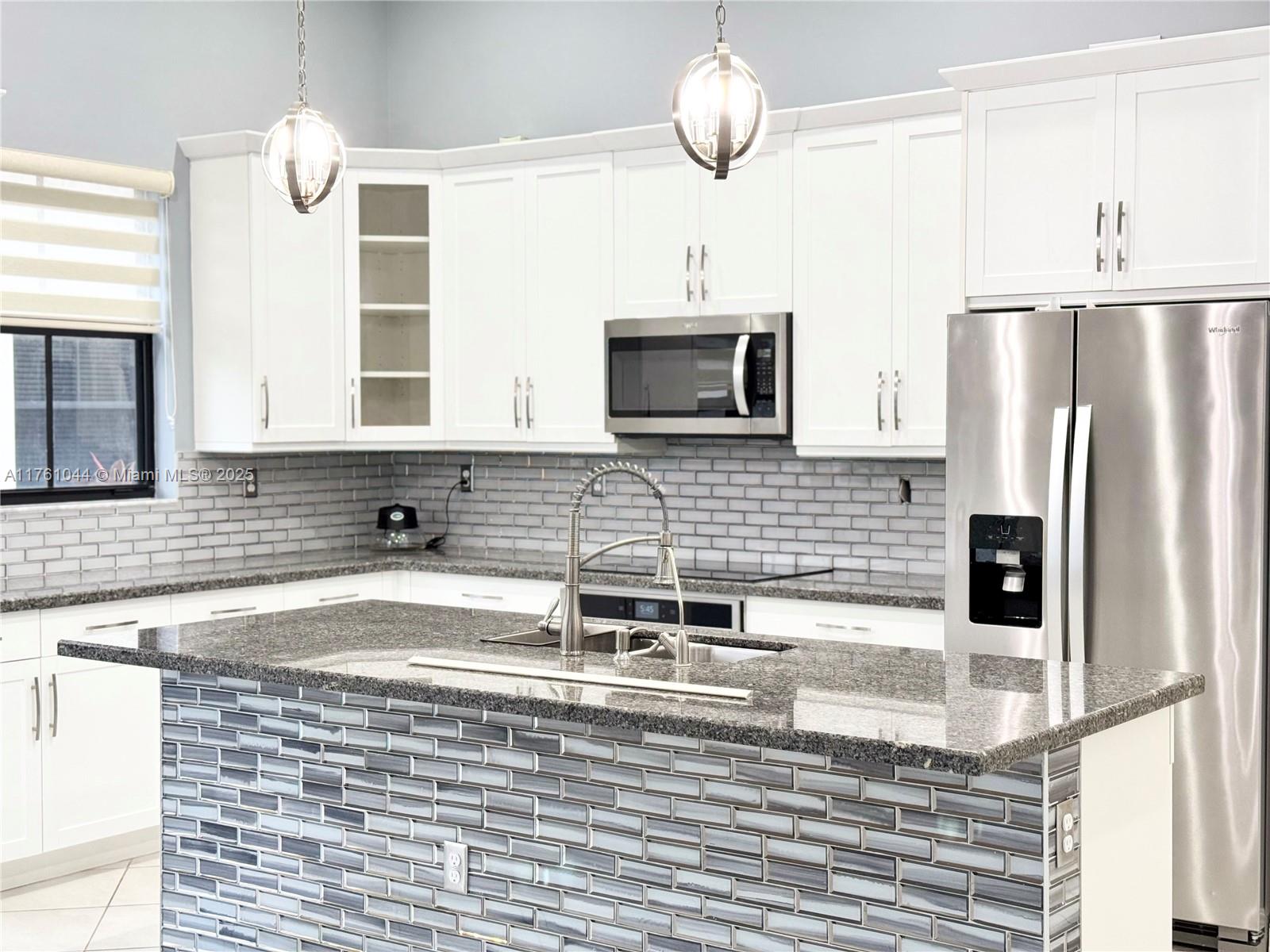 5008 Salerno Street Ave Maria, FL 34142 - Photo 5 of 46 a kitchen with stainless steel appliances kitchen island granite countertop a sink refrigerator stove and microwave