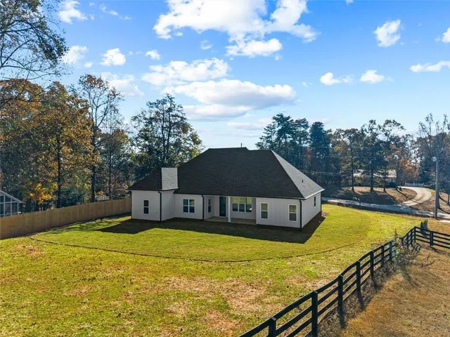 a front view of house with yard and trees in the background