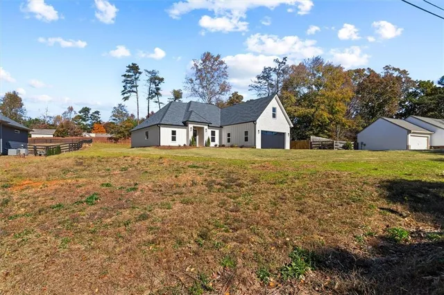 a kitchen with stainless steel appliances granite countertop a sink a stove a refrigerator a center island with wooden floor and cabinets